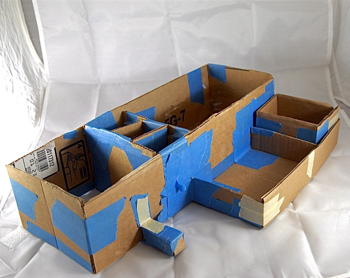 Early desk organizer model made from corrugated cardboard and blue painter's tape
