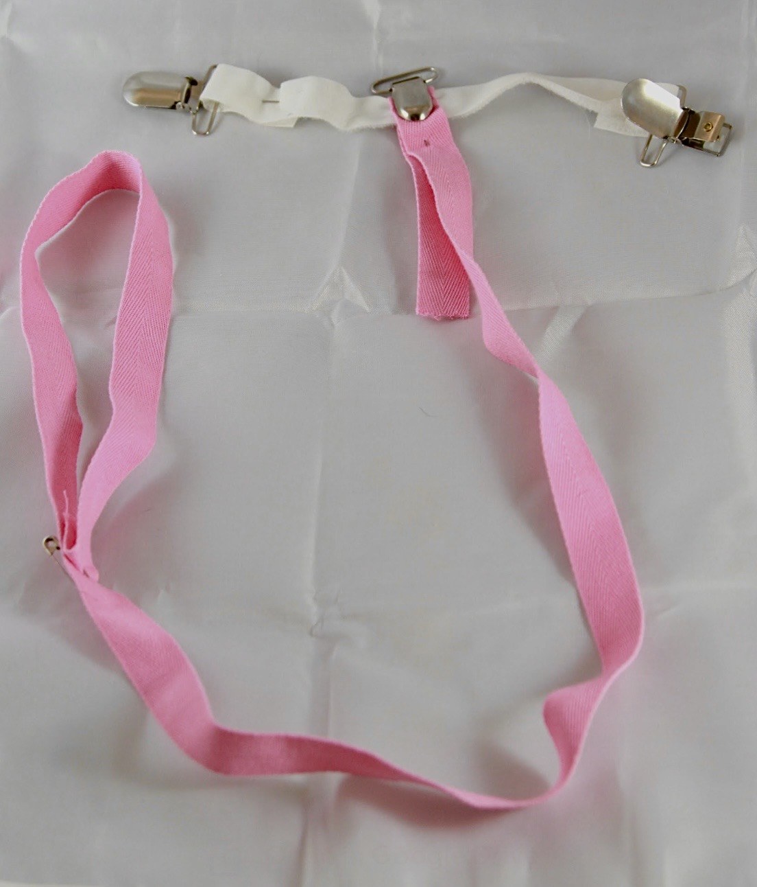 Pink fabric strap system with metal clips designed for one-handed zipper use